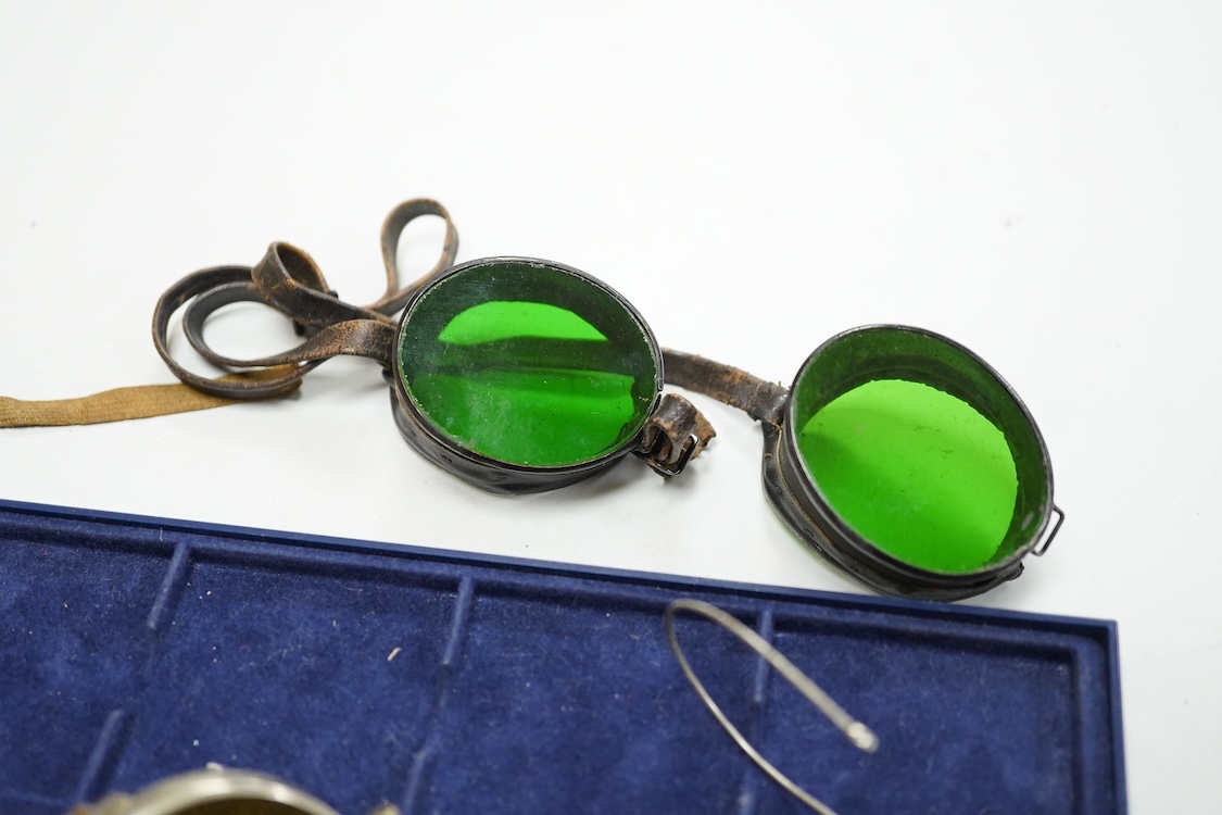 A pair of Wellsworth safety goggles with mesh sides, a pair of green tinted safety goggles with mesh sides, cased, and a pair of mesh wire sided safety spectacles with green tinted lenses (3)